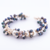 Dozens of mixed color pearls cluster together on a bracelet to resemble coral