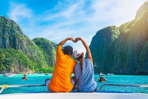 A happy couple on a boat in phuket makes a heat with their arms