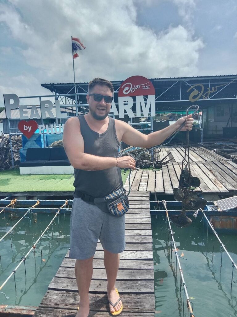 A man holding oysters he picked from the farm