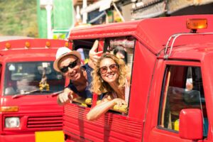 A tourist couple riding a tuk-tuk in Phuket