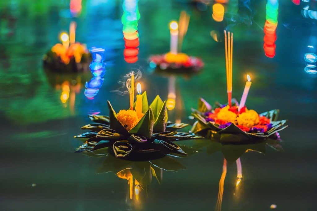 Floating krathongs lit with candles on the water during the Loy Krathong festival Thailand.